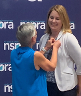 NSPRA member being pinned after earning her APR.